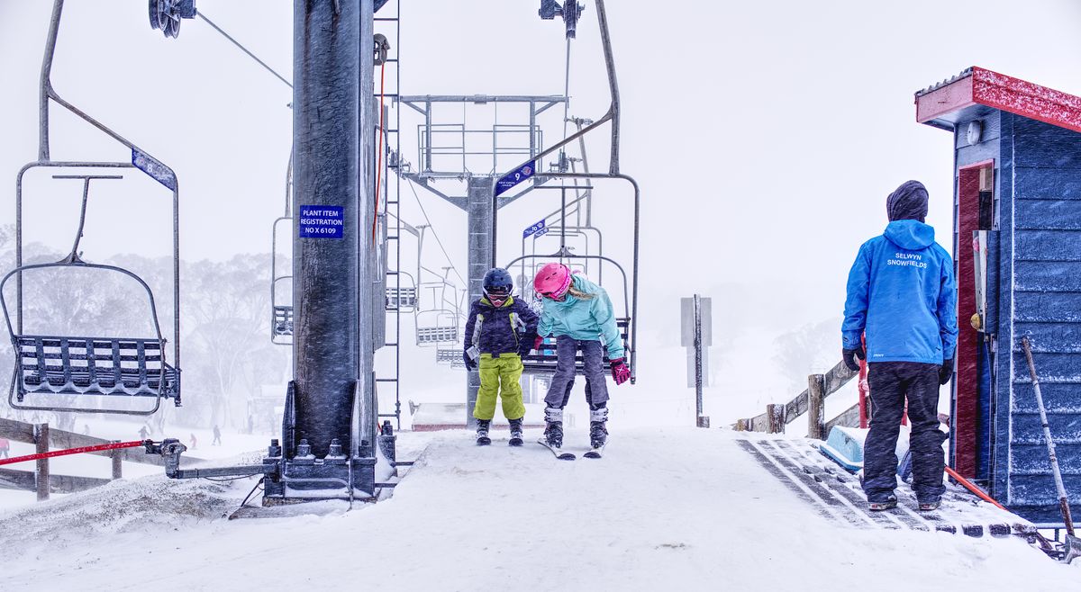 Family in cold-weather gear together on a snowy slope